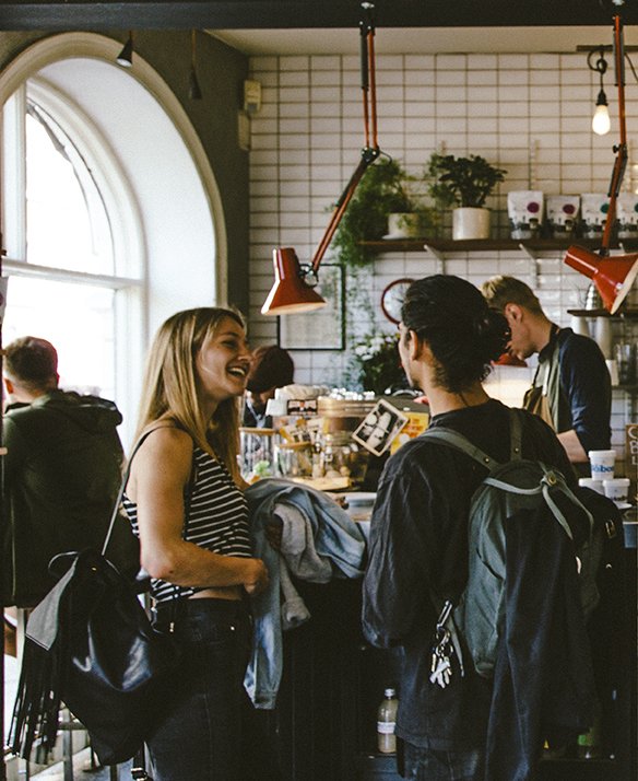 Ett par samtalar stående vid bardisken på en kaffebar