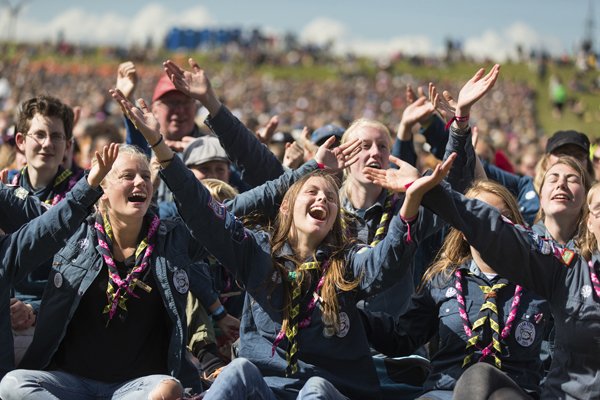 Glada unga människor på scoutevent. Foto.